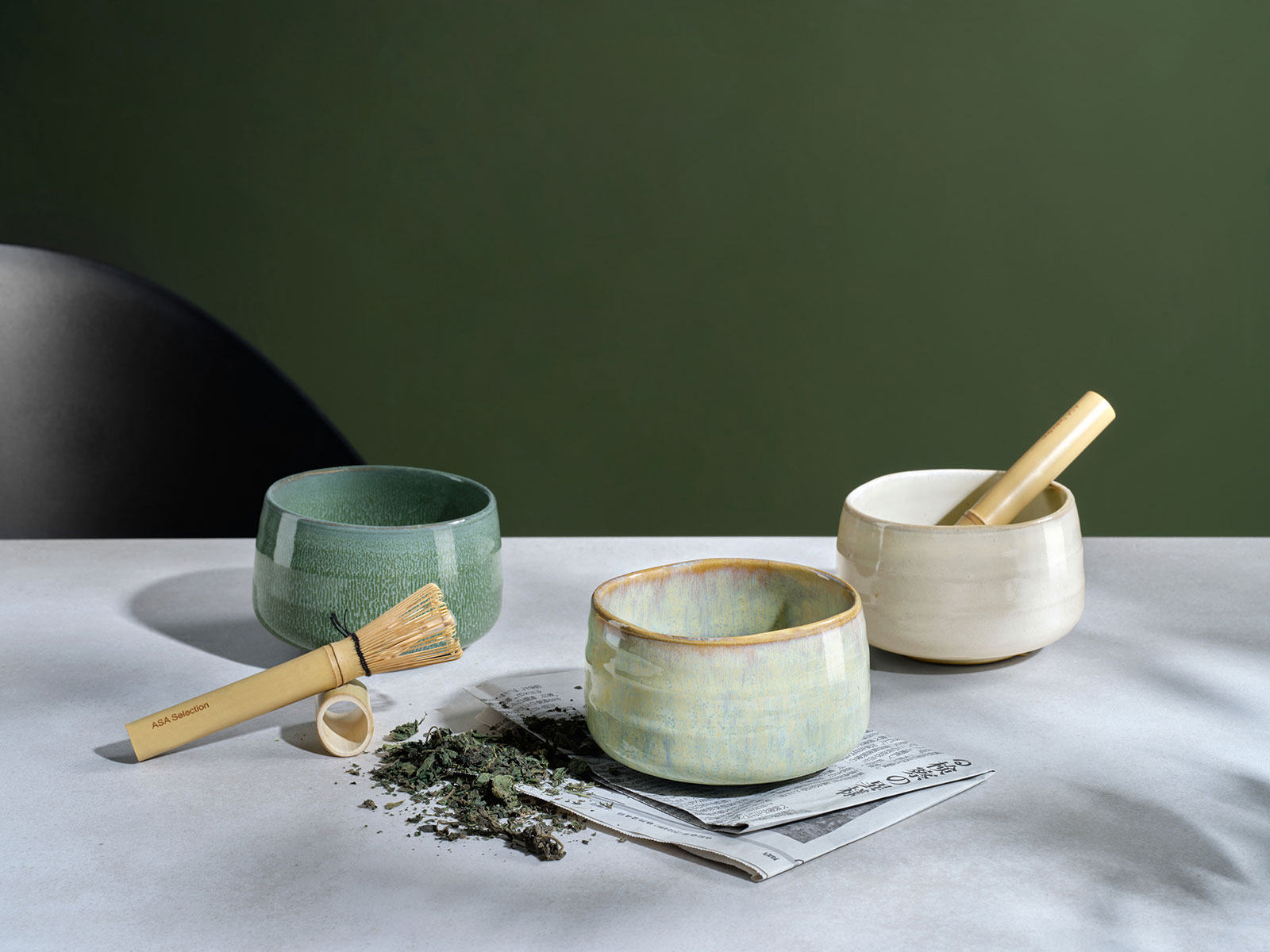 Auf einem hellen Tisch stehen drei Moribana Matcha Schalen, in denen gerade frischer Matcha zubereitet wird.