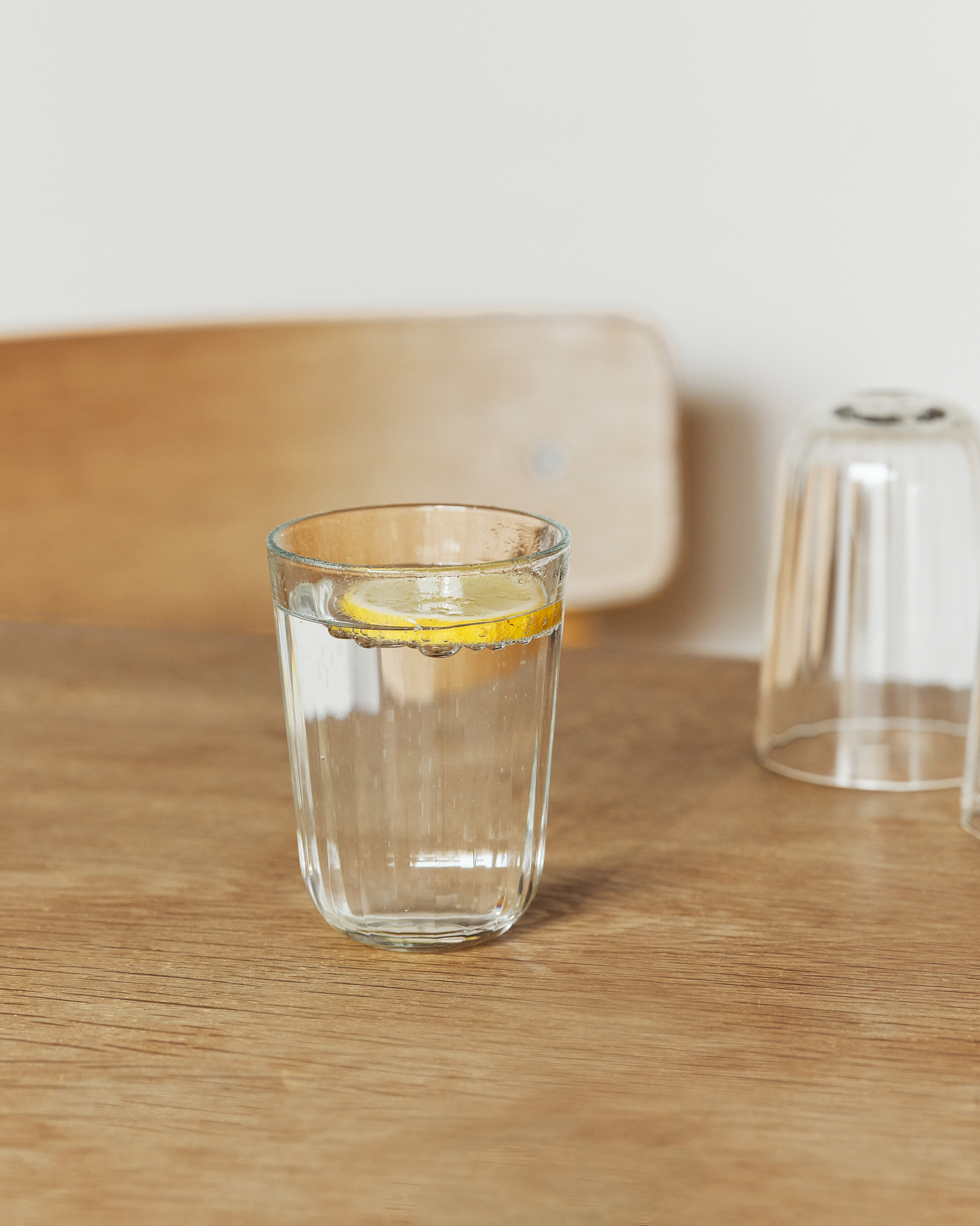 Ein mit Wasser gefülltes Eva Trio Trinkglas auf einem Esstisch.