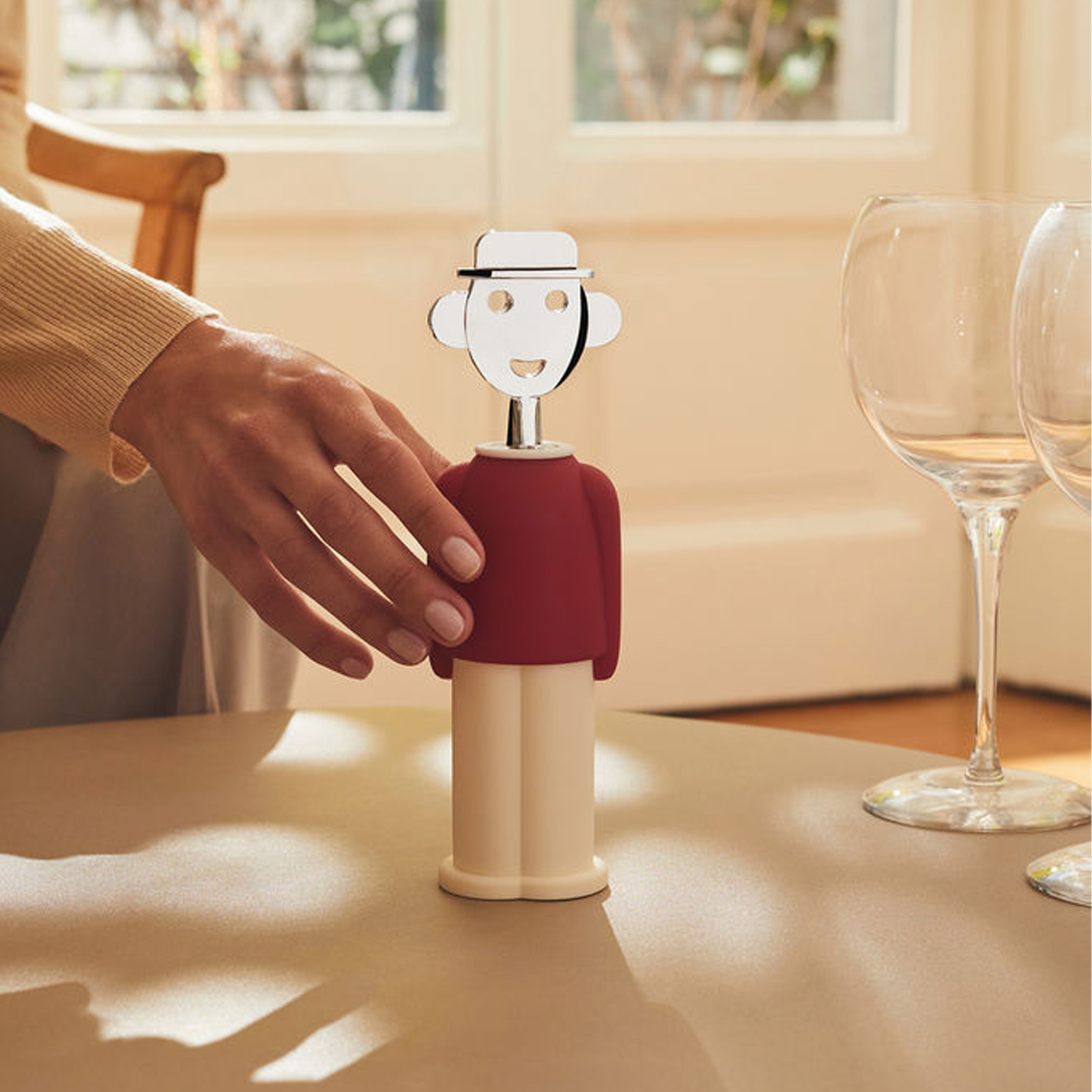 Alessi Alessandro M. Korkenzieher in rot von Alessandro Mendini auf einem gedeckten Tisch.