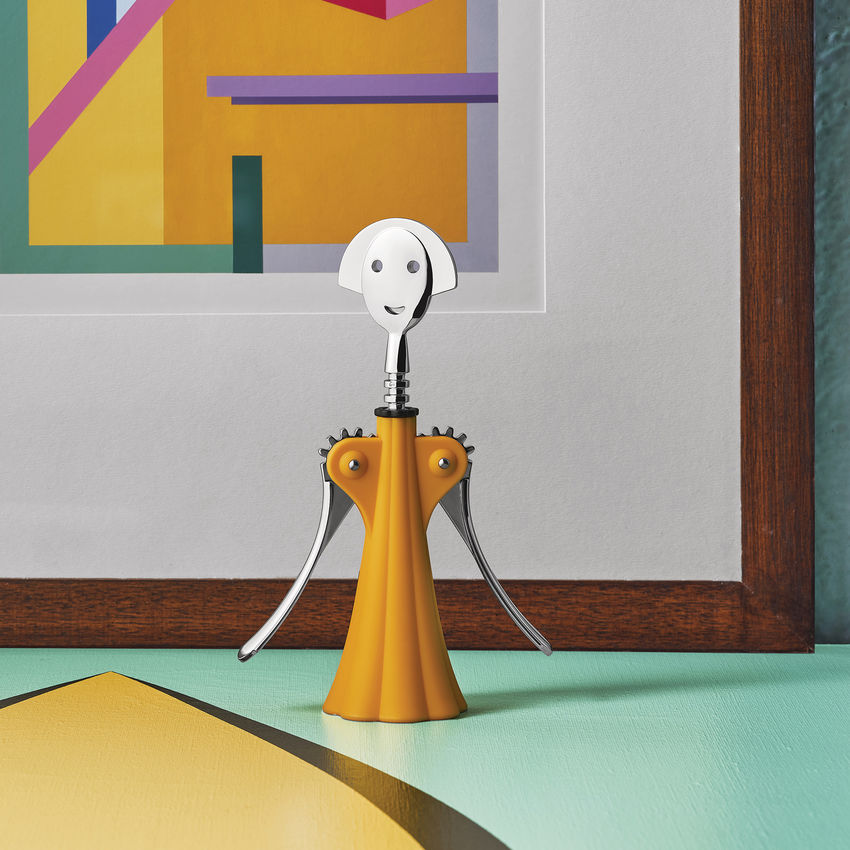 Alessi Anna G. Korkenzieher in gelb von Alessandro Mendini auf einem bunten Tisch.