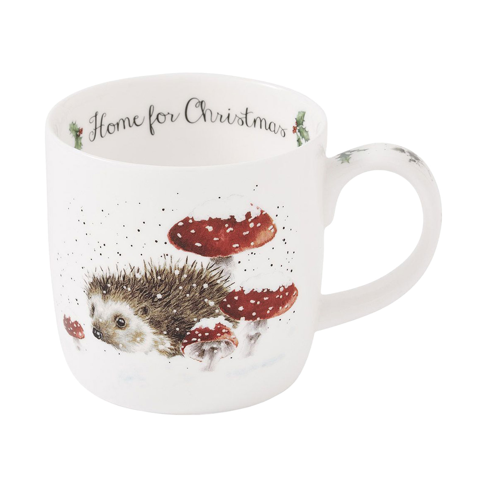 Vorne auf dem Wrendale Designs Becher Home for Christmas schläft ein kleiner Igel unter schneebedeckten Fliegenpilzen.