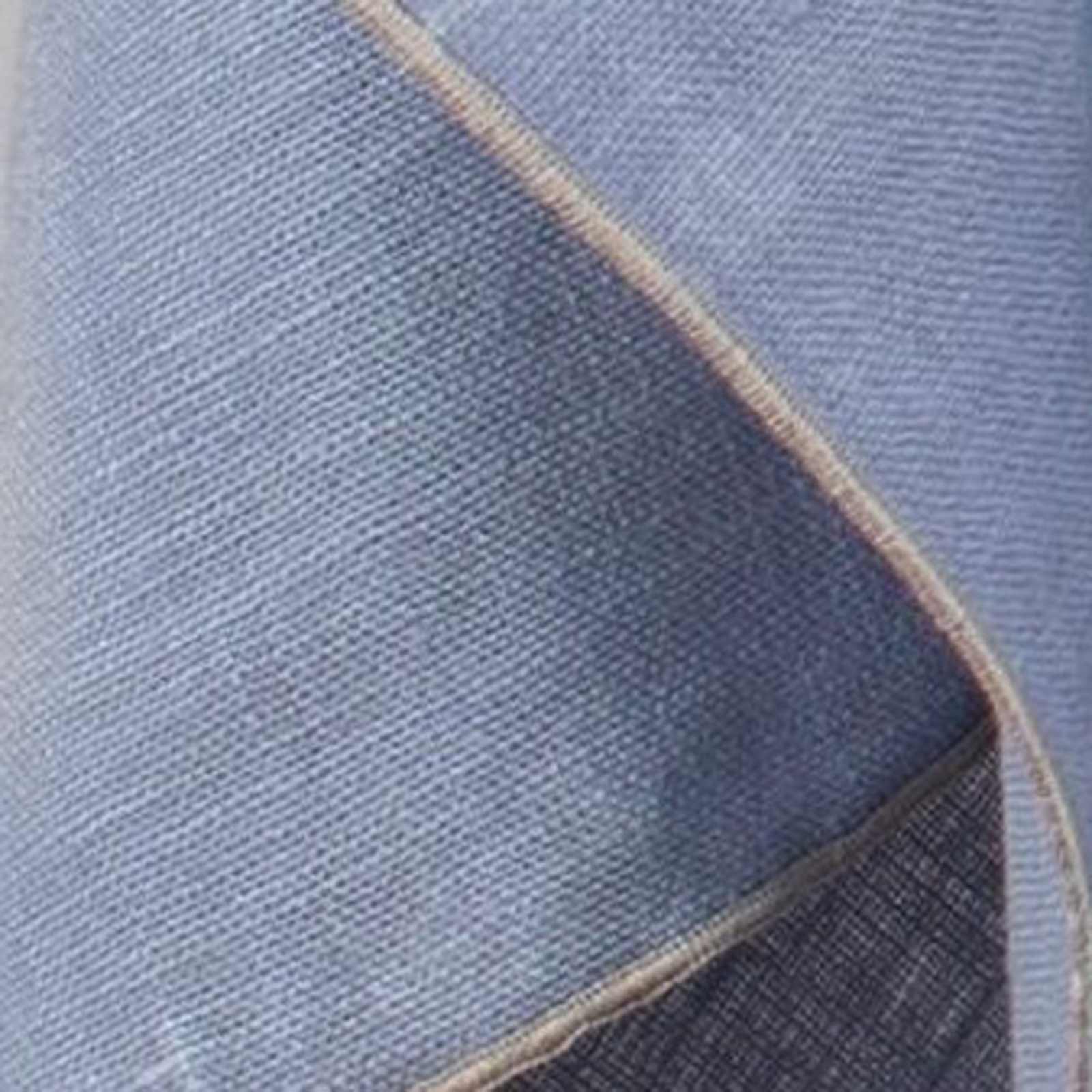 Detailaufnahme der naturbraun umkettelten Borte, die sich vom blauen Leinen abhebt.