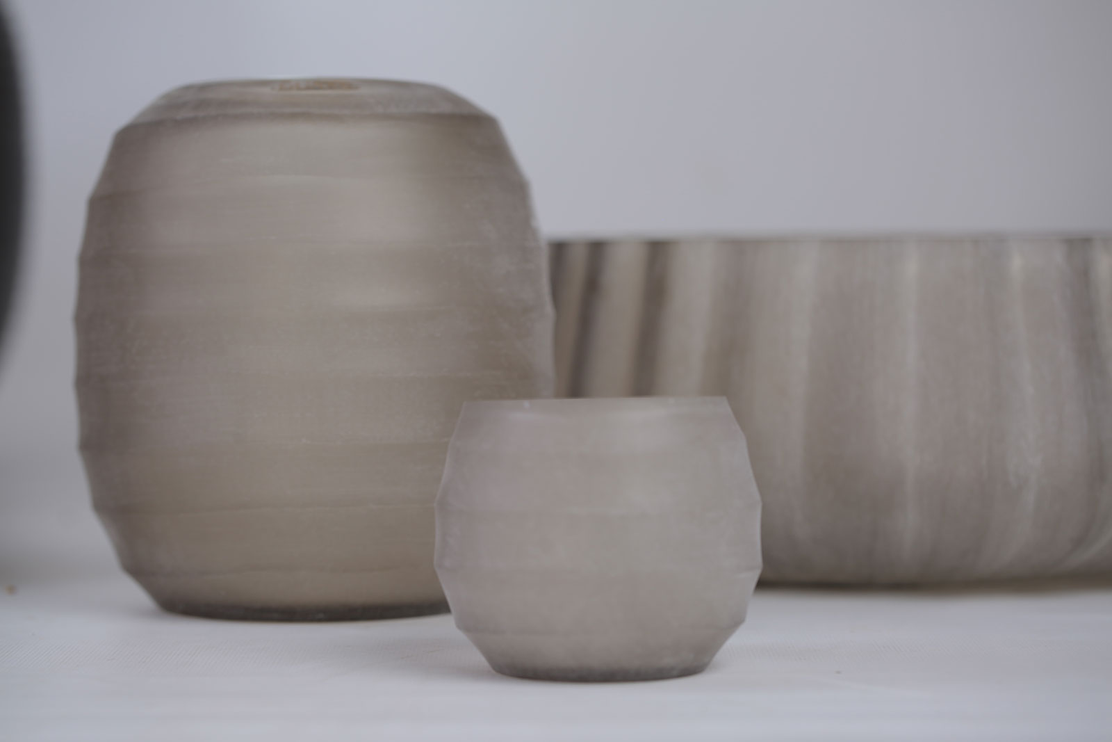 Die Belly Vase und das Windlicht von Guaxs stehen nebeneinander auf einer Anrichte.