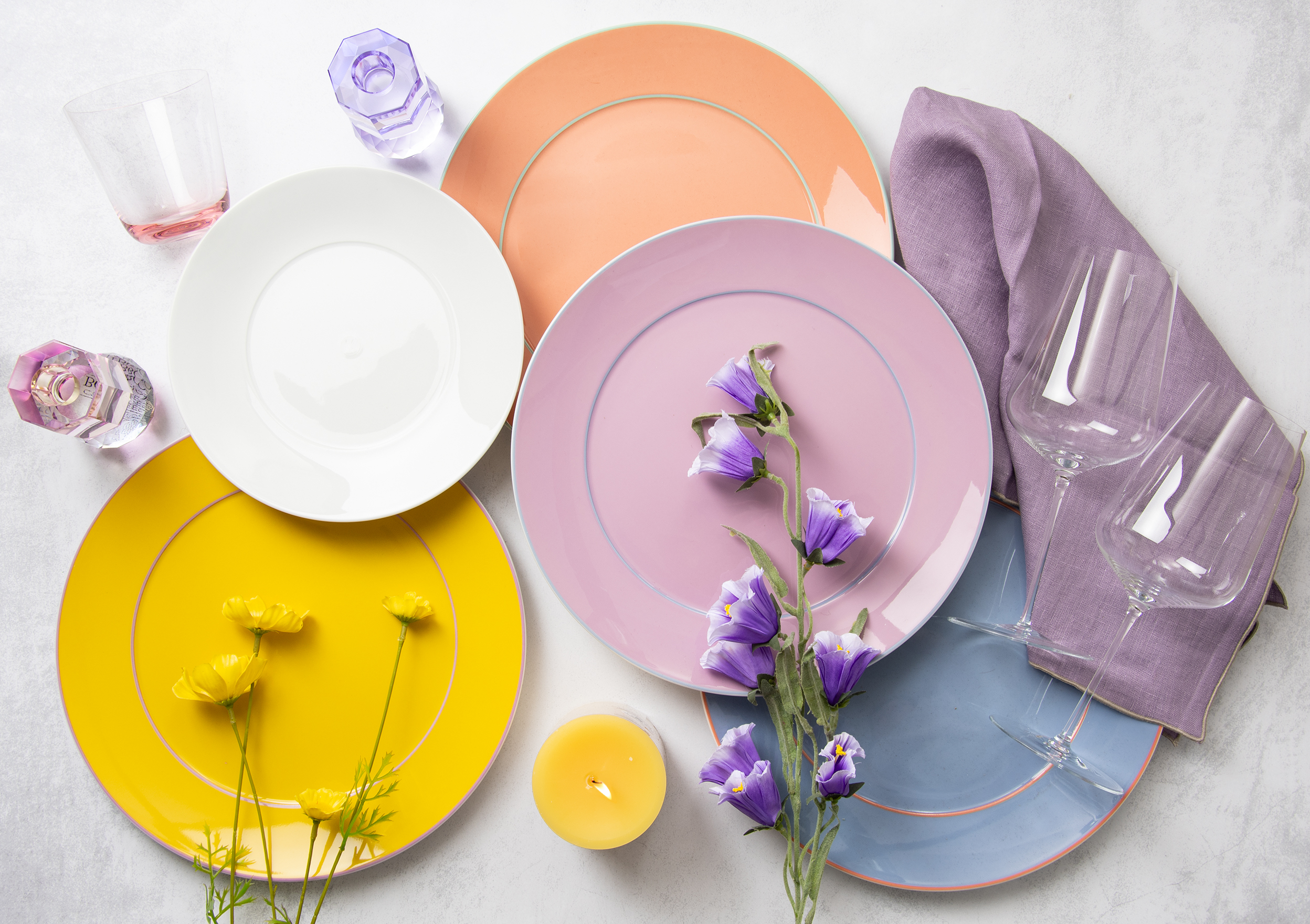 Verschieden farbige Meissen Urban Colors Teller als Stimmungsbild zusammen mit anderen Tischaccessoires auf einem Tisch dekoriert.