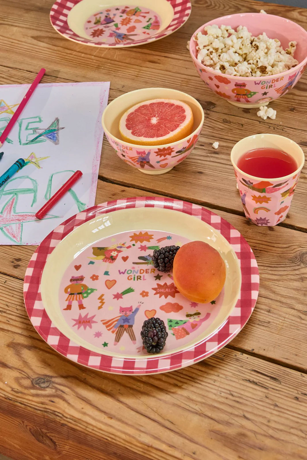 Auf einem Holztisch steht. serviert auf dem Hero Print Kindergeschirr in Pink, ein schönes Frühtstück.