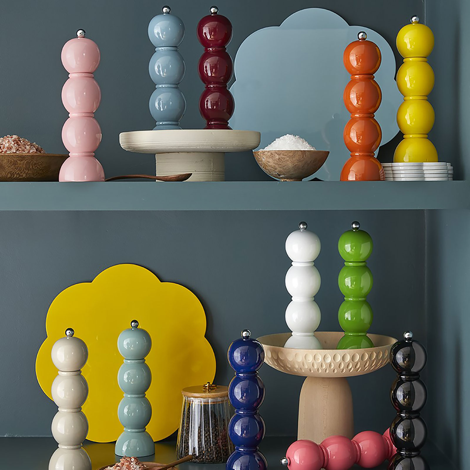 Mehrere bunte Bobbin Salz- und Pfeffermühlen von Addison Ross stehen in einem türkis lackierten Regal.
